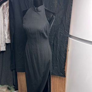 Long black crepe dress with deep side slit .